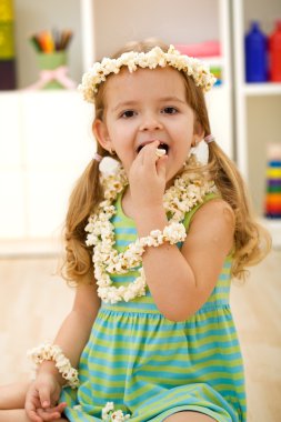 Happy girl eating popcorn - closeup clipart