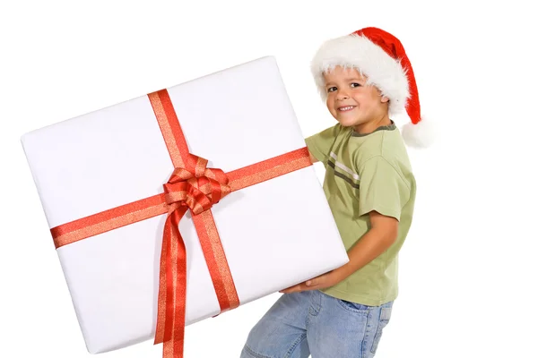 Junge mit Weihnachtsmütze und großem Geschenk — Stockfoto