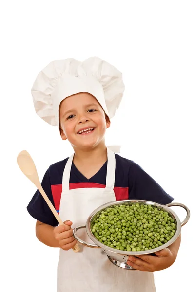 Happy chef with lots of fresh green peas — Stock Photo, Image