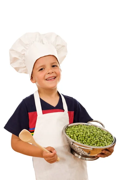 Happy kid with chef hat and a bowl of green peas — Stock Photo, Image