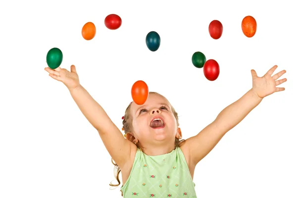 Счастливой кричащей маленькой девочке с падающими пасхальными яйцами — стоковое фото