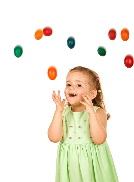 Happy surprised little girl with falling easter eggs — Stock Photo, Image