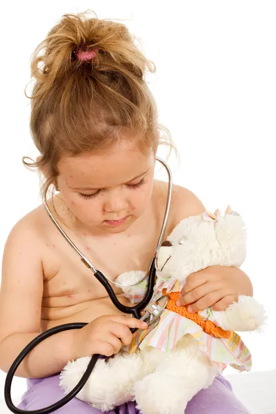 Doktorlar onun oyuncak ayı ile oynarken küçük çiçeği ile küçük kız — Stok fotoğraf
