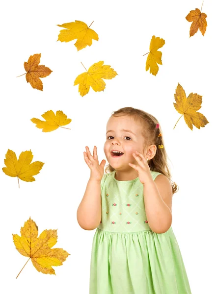 Happy surprised little girl with falling autumn leaves — Stock Photo, Image