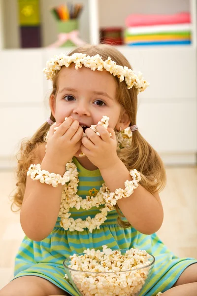 Menina feliz comendo pipocas — Fotografia de Stock