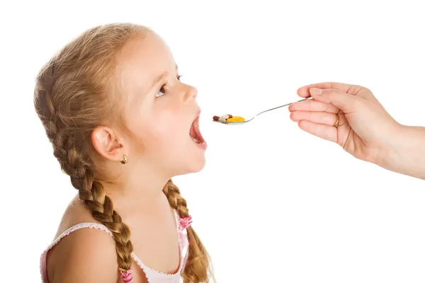 Abuso di droga - bambina che prende pillole con cucchiaio — Foto Stock