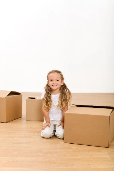 Little girl among cardboard boxes — Stock Photo, Image