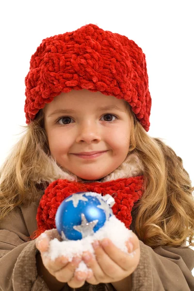 Kleines Mädchen mit einer Handvoll Schnee und Christbaumkugel — Stockfoto
