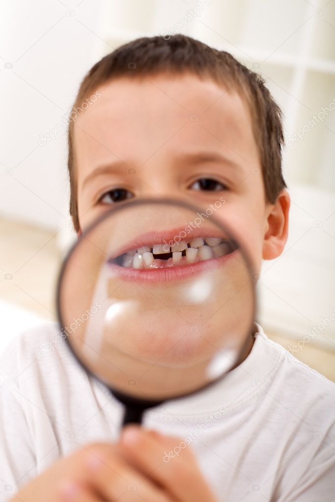 The first lost tooth - boy with magnifier