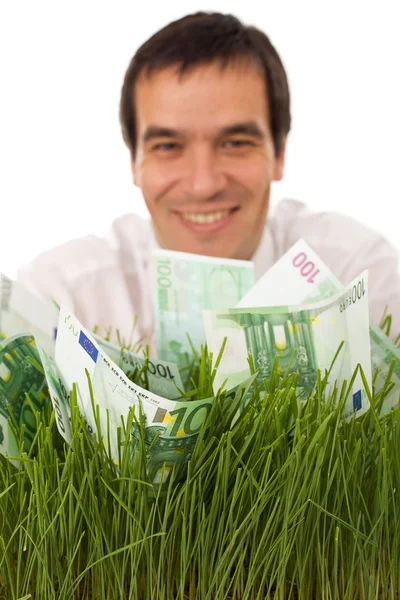 Geschäftsmann mit grünen Geldscheinen im Gras — Stockfoto