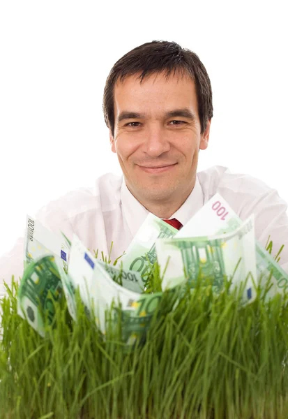 Впевнений бізнесмен з зеленими банкнотами в траві - ізолат — стокове фото