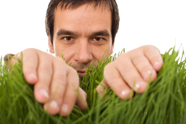 Homem escondido atrás de lâminas de grama — Fotografia de Stock