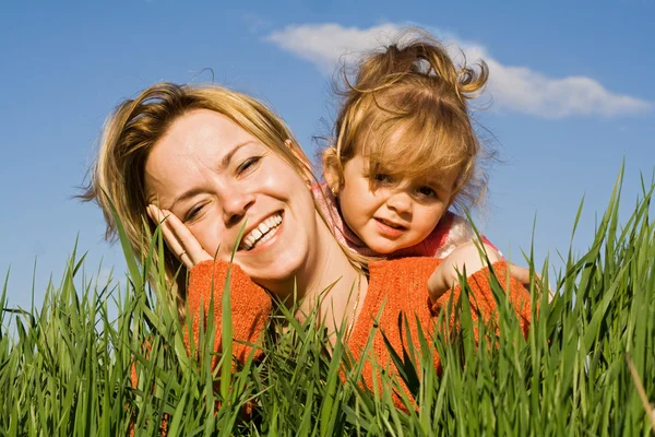 Woman and little girl in the grass — Stock Photo, Image