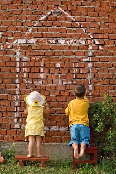 Two kids drawing a home — Stock Photo, Image
