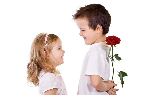Garçon donnant rose à une petite fille — Photo