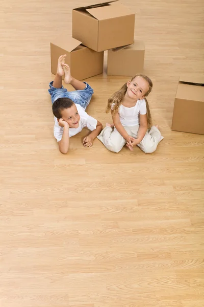 Niños en el suelo en su nuevo hogar — Foto de Stock