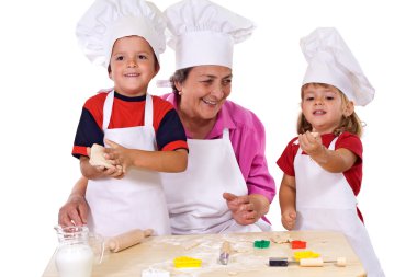 Grandmother with kids making cookies clipart