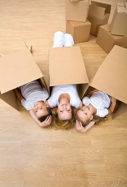 Familjen vilar på golvet i sitt nya hem — Stockfoto