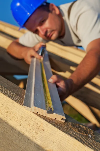 Construtor carpinteiro medindo planck de madeira — Fotografia de Stock