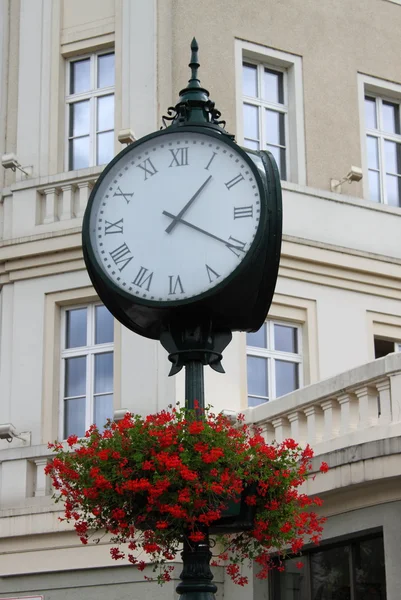 Stary styl ulicy zegar z kwiatami — Zdjęcie stockowe
