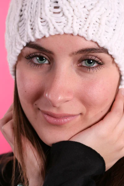 Meisje in wol hoed op roze achtergrond — Stockfoto