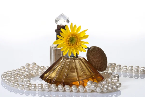 Vintage parfüm palackok, gyöngyök & sárga virág — Stock Fotó