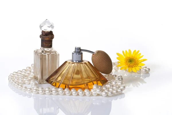 Vintage parfüm palackok, gyöngyök & sárga virág Stock Fotó