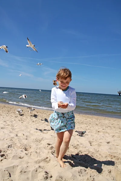Девушка, играющая на пляже — стоковое фото