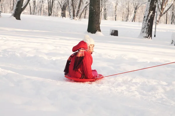 Ein kleines Kind beim Schlittenfahren im Schnee — Stockfoto