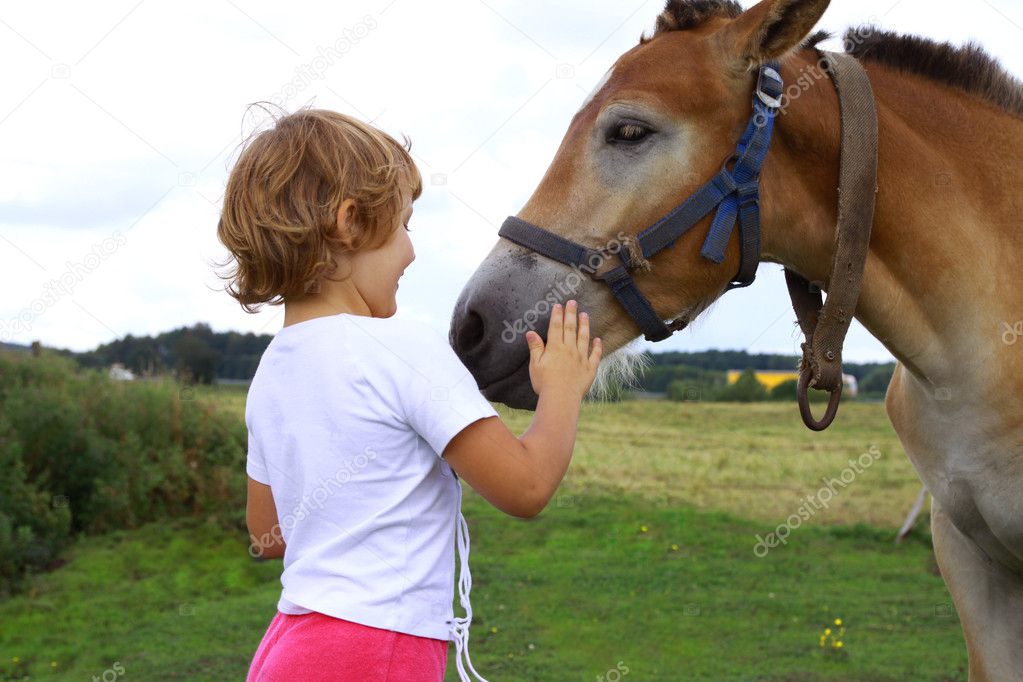 Young girl stroking horse
