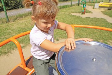 Young girl on the carousel clipart