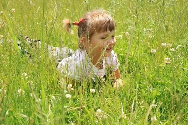 Quatro anos de idade menina jaz na grama — Fotografia de Stock