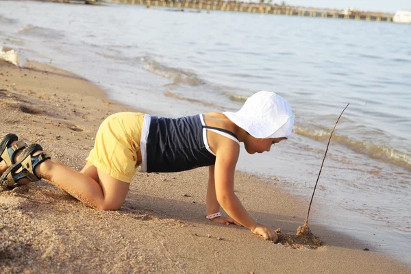 Молода дівчина грає з палицею на пляжі — стокове фото
