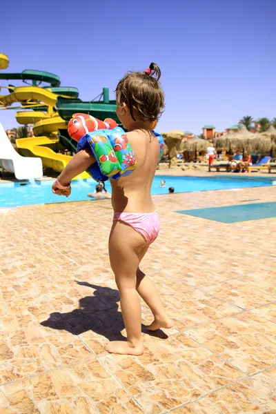 Chica joven entra en la piscina — Foto de Stock