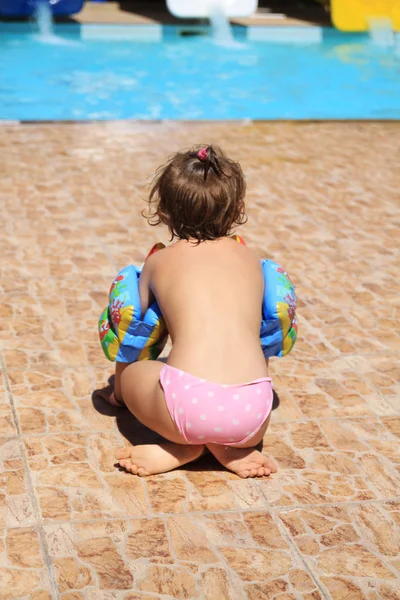 Malá holka sedí u bazénu — Stock fotografie