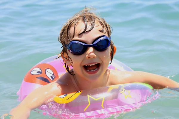 Een klein kind zwemt in de zee — Stockfoto