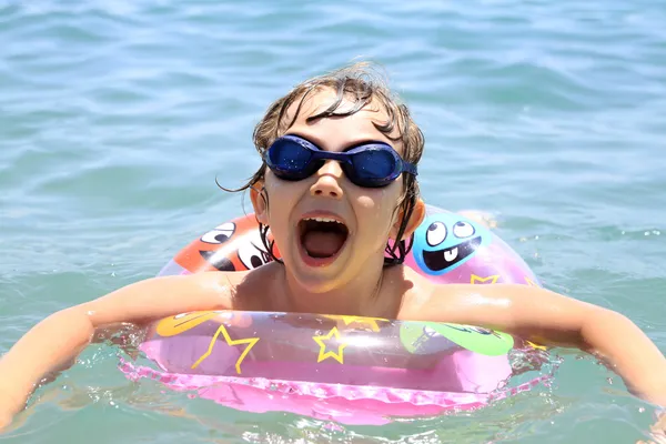 Een klein kind zwemt in de zee — Stockfoto