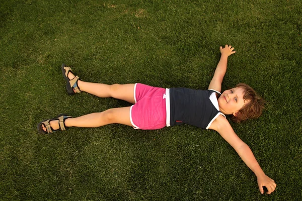 Young girl lie on green grass — Stock Photo, Image