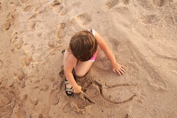 Девушка, играющая на пляже — стоковое фото
