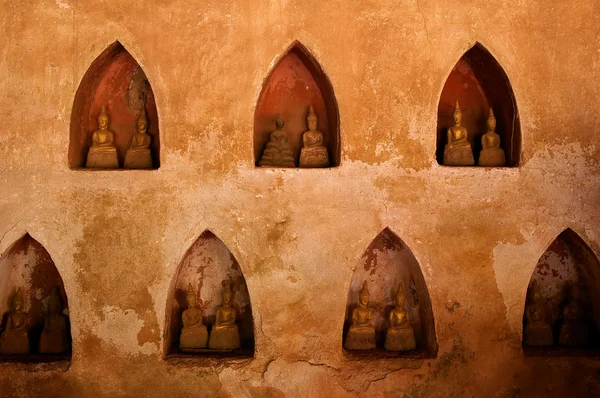 Muur met kleine boeddhabeelden — Stockfoto