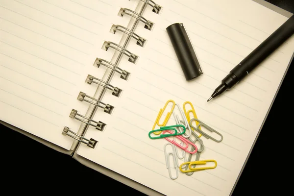 Detail of a notepad with pencil and paperclips — Stock Photo, Image