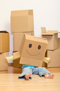 Little girl having fun in her new home unpacking clipart