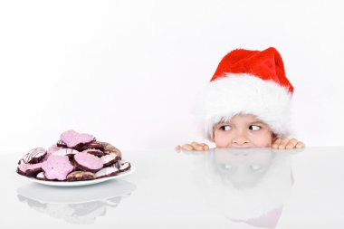 Boy peeking at the christmas gingerbread cookies clipart