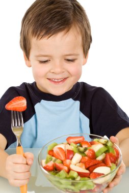 Boy about to eat a large bowl of fresh fruit salad clipart