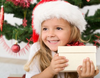 Happy little girl with christmas present clipart