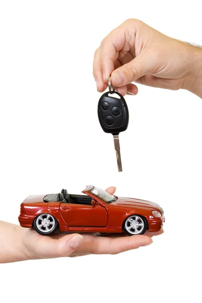 Handen met rode auto en de sleutel — Stockfoto