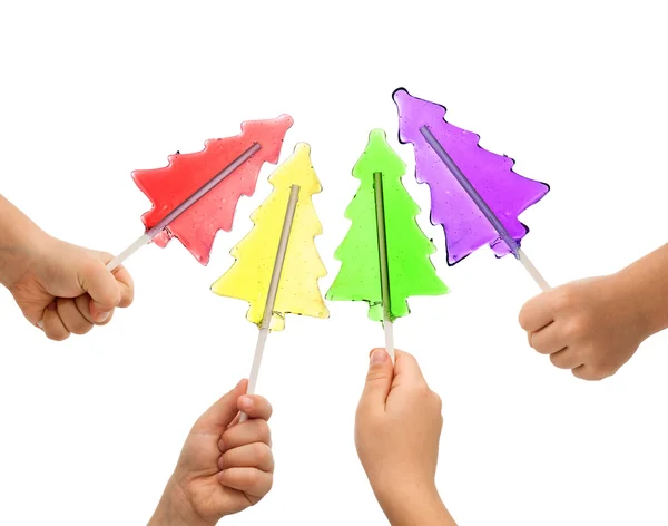 Lollipops coloridos del árbol de Navidad en manos de los niños — Foto de Stock