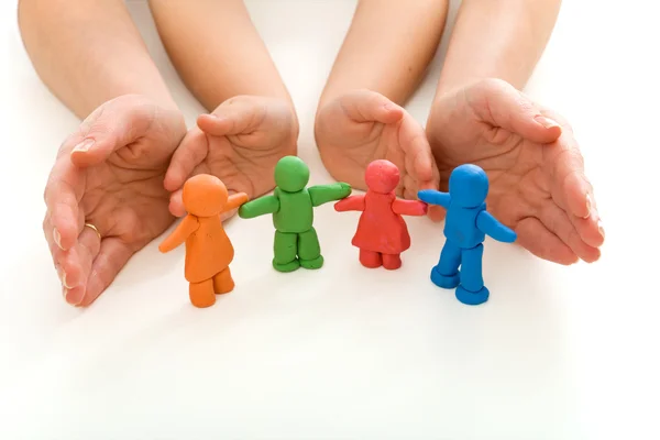 Woman and child hands protecting modelling clay — Stock Photo, Image