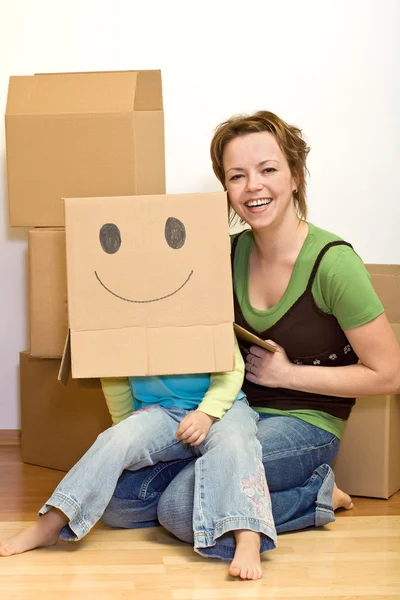 Маленька дівчинка і жінка весело переїжджають в новий будинок — стокове фото