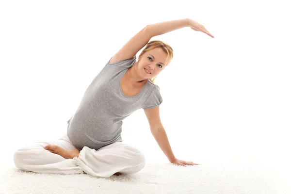 Hermosa mujer embarazada haciendo ejercicios de estiramiento —  Fotos de Stock